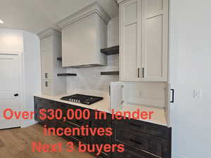 Kitchen with open shelves, decorative backsplash, light countertops, and dark wood-type flooring