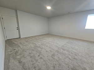 Unfurnished room with light carpet and baseboards