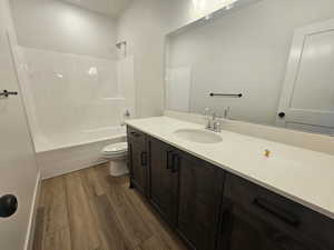Full bathroom featuring dark wood-style floors, shower / tub combination, and vanity