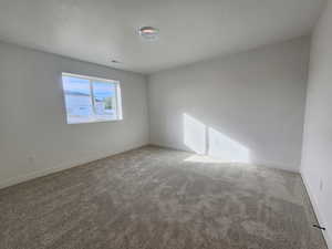 Unfurnished room with light carpet and a textured ceiling