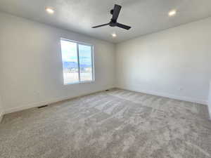 Spare room with light carpet, recessed lighting, ceiling fan, and a mountain view