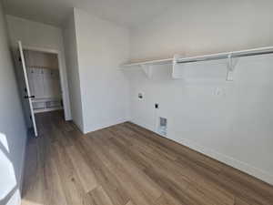 Laundry area with washer hookup, wood finished floors, and hookup for an electric dryer