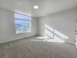 Unfurnished room featuring light colored carpet and baseboards