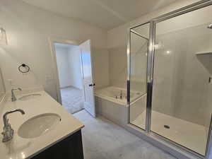 Full bathroom with a stall shower, a bath, double vanity, and light marble finish flooring