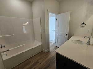 Bathroom featuring vanity, dark wood-style flooring, and tub / shower combination