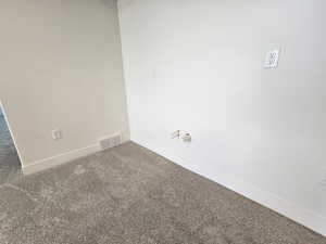 Carpeted empty room featuring baseboards