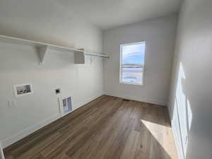 Laundry room with hookup for a washing machine, electric dryer hookup, and light wood-style floors