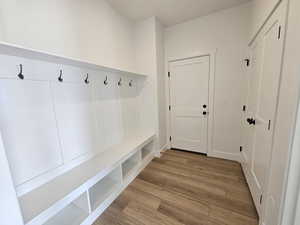 Mudroom with light wood-style flooring and baseboards