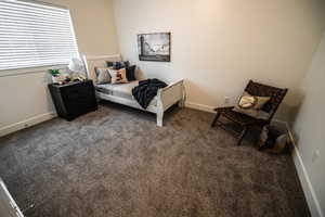 Bedroom featuring dark carpet and baseboards