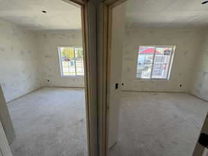 Unfurnished room with a textured ceiling and plenty of natural light