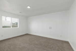 Unfurnished room featuring carpet and baseboards