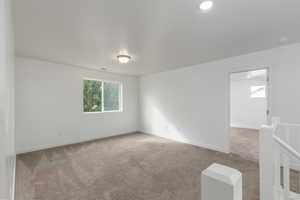 Carpeted spare room with baseboards