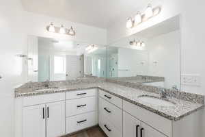 Bathroom featuring double vanity and wood finished floors