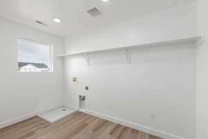Laundry room with light wood-type flooring, washer hookup, electric dryer hookup, and recessed lighting