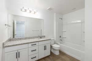 Bathroom featuring light wood-style floors, vanity, and washtub / shower combination