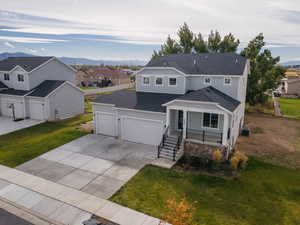 Traditional-style house featuring roof with shingles, a residential view, a porch, and a front lawn
