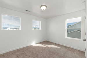 Carpeted spare room with baseboards