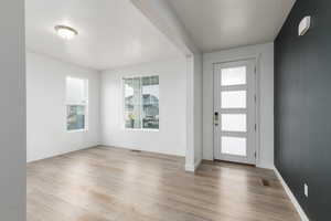 Foyer entrance with light wood-style flooring