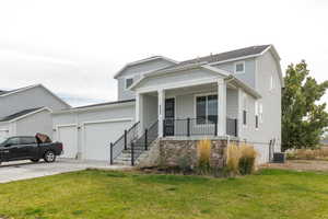 View of front of home featuring covered porch, a front yard, and concrete driveway