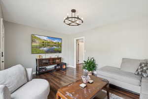Living area featuring a chandelier and dark wood finished floors