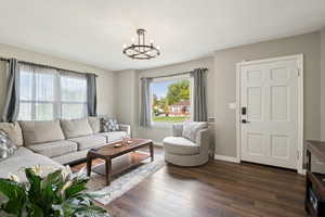 Living area with dark wood-type flooring and a chandelier