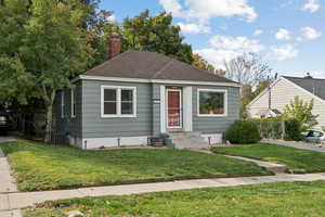 Bungalow-style house featuring roof with shingles, a chimney, and entry steps