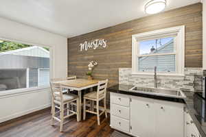Dining area featuring wood walls and dark wood-style floors