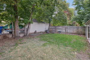 Fenced backyard featuring view of scattered trees
