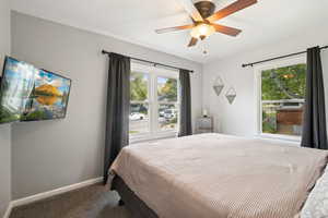 Bedroom featuring carpet floors, multiple windows, and a ceiling fan