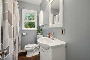 Bathroom with vanity, a shower with shower curtain, dark wood-style floors, and a textured ceiling