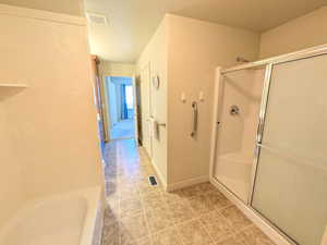 Full bathroom featuring a stall shower and a bath