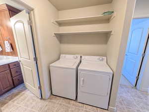 Washroom featuring independent washer and dryer and light tile patterned flooring