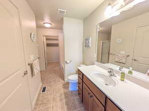 Bathroom featuring vanity, a shower with door, and light tile patterned floors