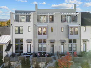 Contemporary house featuring outdoor lounge area, stucco siding, and a pergola