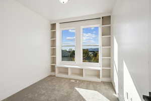 Empty room with light carpet and built in features