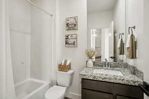 Bathroom featuring vanity and shower / bathtub combination with curtain