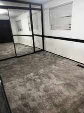 Unfurnished bedroom featuring dark colored carpet and a closet