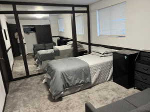 Bedroom featuring a closet, carpet flooring, and black refrigerator