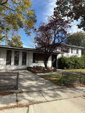 View of front of property with a gate, a fenced front yard, and a porch