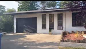 View of front of house featuring concrete driveway and a porch