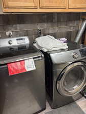 Washroom featuring cabinet space and washing machine and clothes dryer