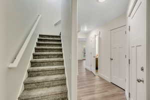 Stairway with wood finished floors and baseboards