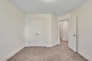 Unfurnished bedroom featuring carpet flooring and a closet