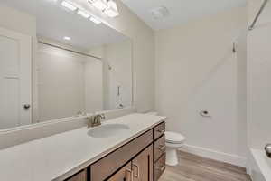 Full bath with vanity, light wood-type flooring, and  shower combination