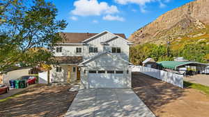 View of front facade featuring board and batten siding, concrete driveway, roof with shingles, a mountain view, and a carport