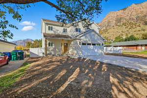 Traditional-style house with a mountain view, a gate, driveway, covered porch, and an attached garage