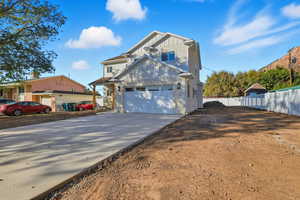 View of front of property featuring board and batten siding, driveway, and a garage
