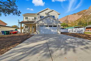 View of front of home with board and batten siding, driveway, a porch, and a mountain view