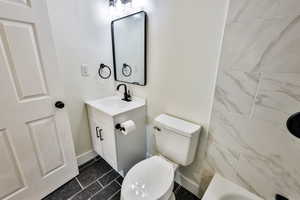 Full bathroom with vanity and dark marble finish floors