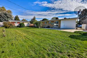 Rear view of house with a patio, brick siding, and a chimney